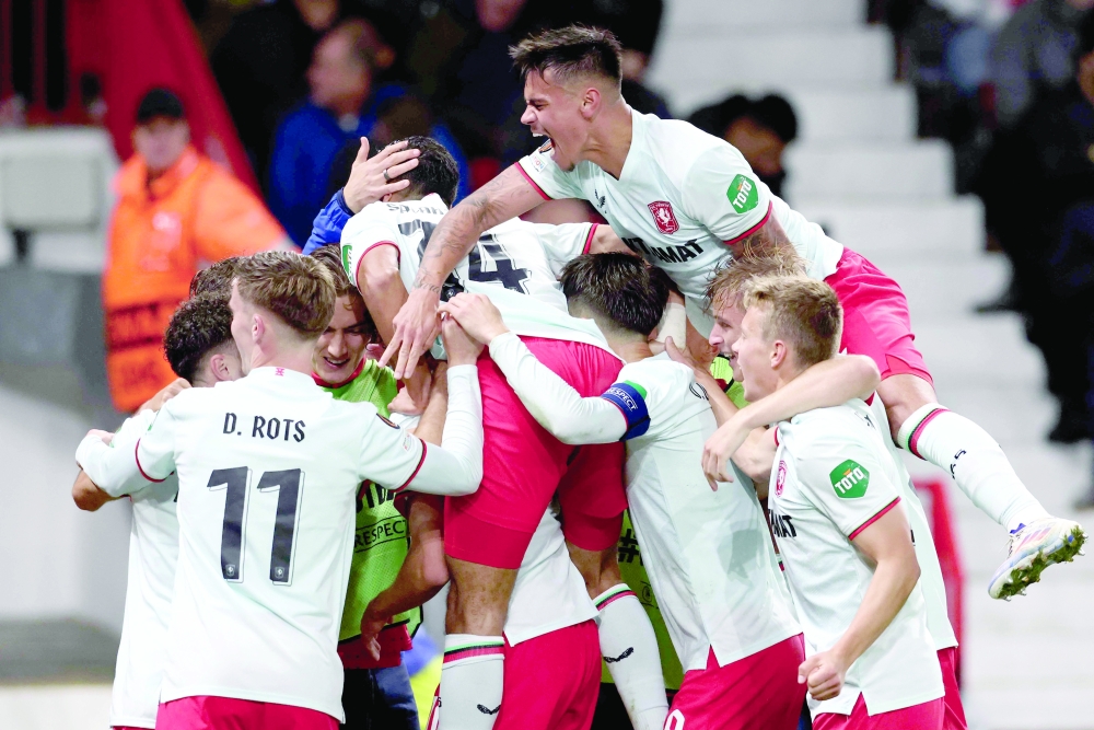 FC Twente's Dutch forward #10 Sam Lammers (not seen) celebrates with his team after scoring a goal during the UEFA Europa league stage football match between Manchester United and FC Twente at Old Trafford stadium in Manchester, north west England, on September 25, 2024. (Photo by Darren Staples / AFP)


