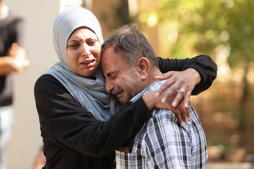 Mourners react at the funeral of people killed in an Israeli attack on Sunday in the city of Ain Deleb in southern Lebanon 