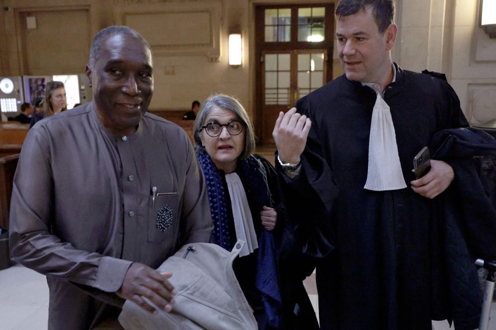 Rwandan doctor Eugene Rwamucyo (L) and lawyers arrive at the Paris Assize Court. — AFP 