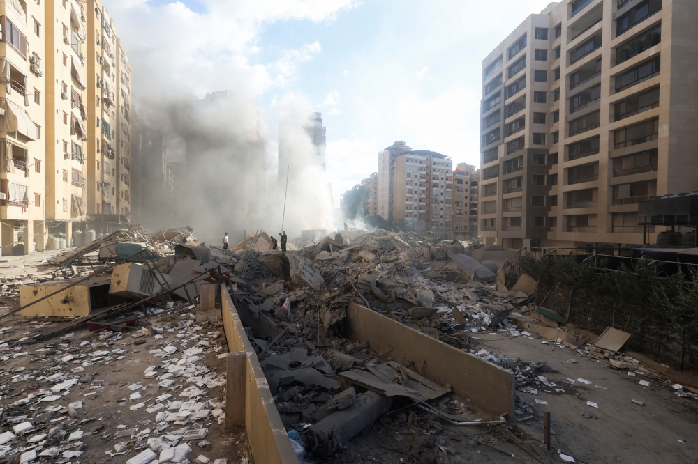 People stand amid debris in the aftermath of Israeli strikes in Chiyah, Lebanon. — Reuters 