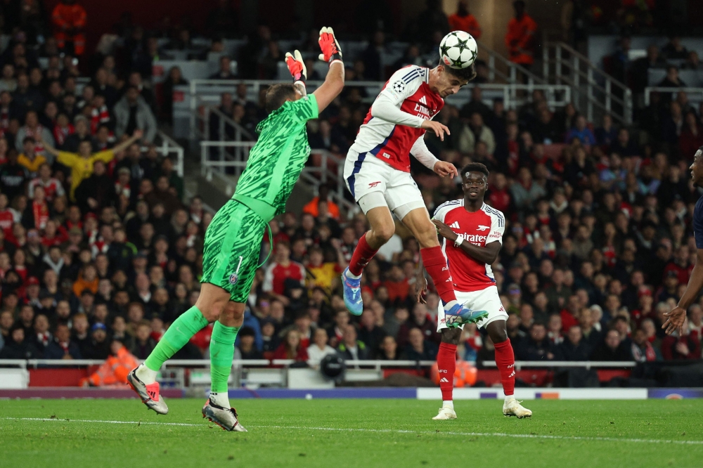 Arsenal's German midfielder #29 Kai Havertz headers th e ball to score the opening goal during the UEFA Champions League football match between Arsenal and Paris Saint-Germain (PSG) at the Emirates Stadium in north London on October 1, 2024.  (Photo by Adrian Dennis / AFP)

