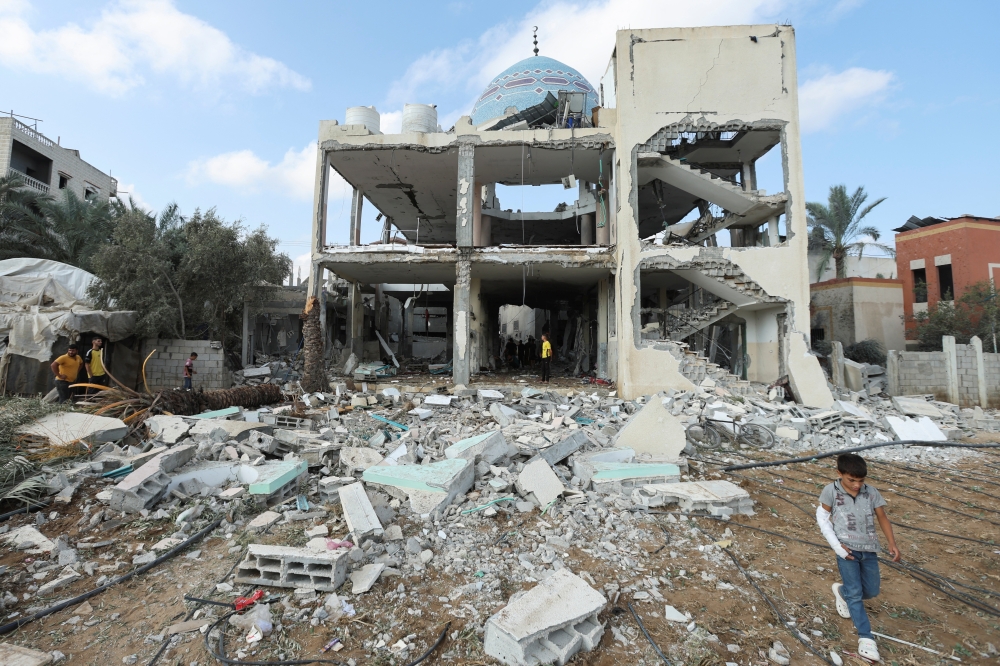 Palestinians inspect the site of an Israeli strike on a mosque sheltering displaced people