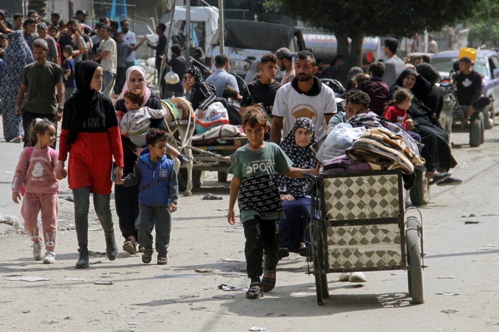 Displaced Palestinians make their way as they flee areas in the northern Gaza Strip. — Reuters 