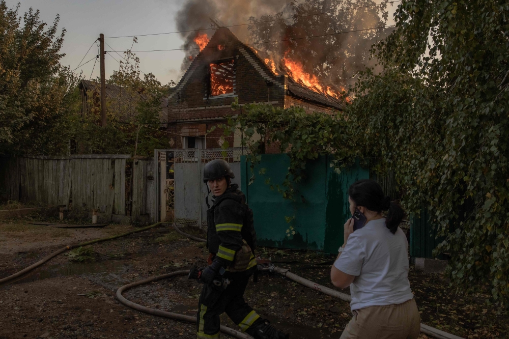 Ukrainian firefighters try to extinguish the fire in a house following an air attack, eastern Donetsk region. — AFP 