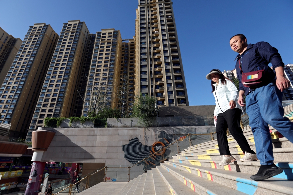 People walk past residential buildings braving the heat.