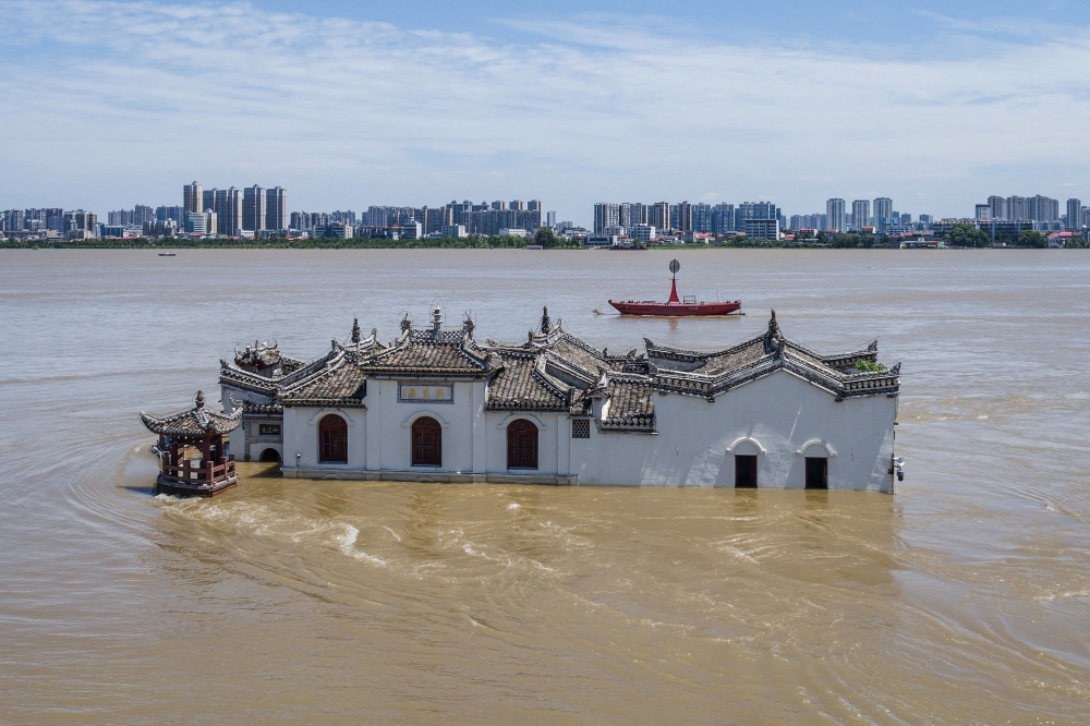The photo taken on July 6 shows an aerial view of a partially submerged Guanyin temple in floodwaters in the swollen Yangtze River, in Ezhou, in central China's Hubei province. - AFP

