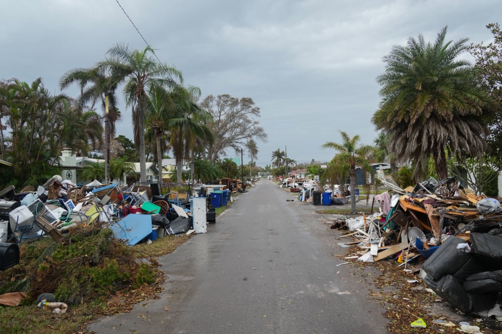 Debris from Hurricane Helene lines a street in the Redington Beach section of St. Petersburg, Florida, on October 8, 2024