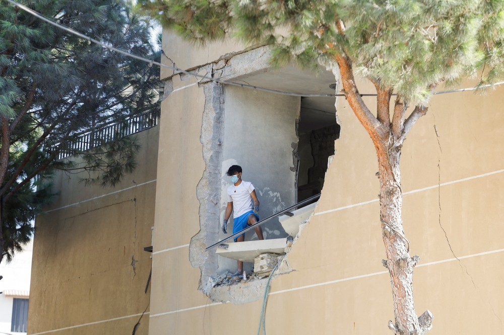 A man stands on a damaged building in the aftermath of an Israeli strike that hit a building, in Wardaniyeh, Lebanon, on Wednesday. — Reuters