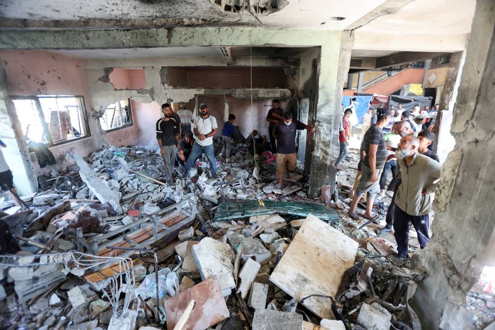 Palestinians inspect the site of an Israeli strike on a school sheltering displaced people in Deir Al Balah, in the central Gaza Strip, on Thursday. — Reuters