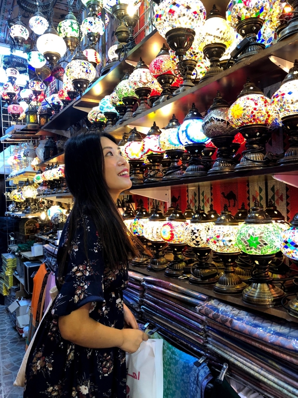 Hyeji Kim gazes at the Turkish mosaic hanging lights at Muttrah souq