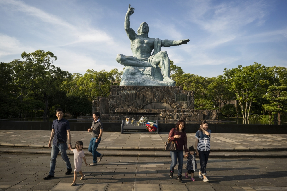 Tourists visit the Peace Statue in the Nagasaki Peace Park, which commemorates the atomic bombing of the city, on May 23, 2016. (Adam Dean/The New York Times)