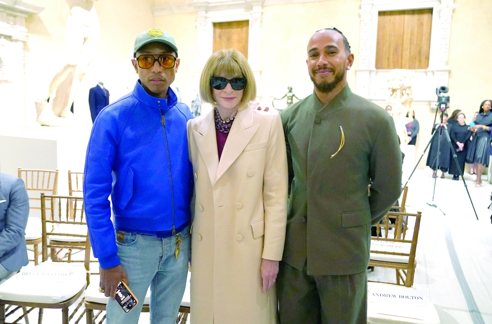 Met Gala celebrity Pharrell Williams and Lewis Hamilton pose with Vogue editor Anna Wintour at the Metropolitan Museum of Art's Costume Institute during a press conference.