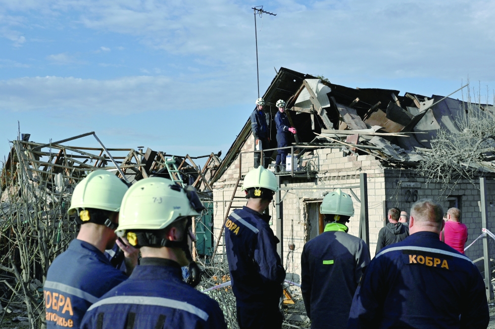 Rescuers inspect a house damaged by an air strike in Zaporizhzhia. — Reuters
