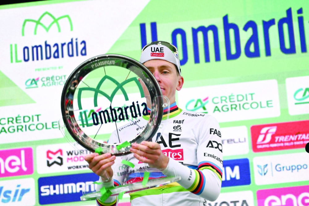 Tadej Pogacar celebrates his victory with the trophy. — AFP