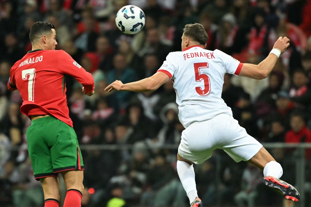 Portugal's #07 Cristiano Ronaldo and #05 Jan Bednarek 