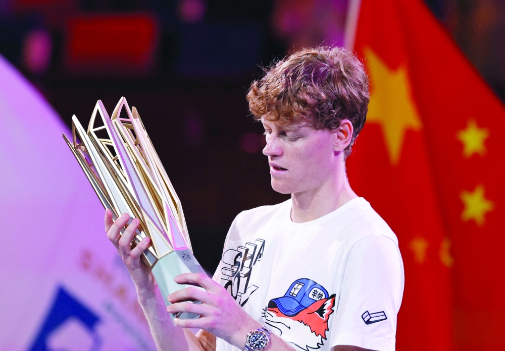  Jannik Sinner lifts the winner's trophy. — Reuters