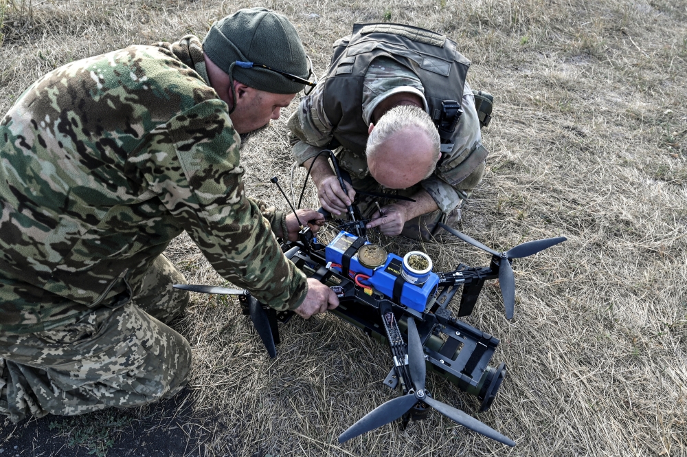 Ukrainian servicemen of the 'Bulava' Unmanned Aerial Vehicles Unit of the Separate Presidential Brigade prepare for a test fly an FPV drone with attached portable grenade launcher at their position near a frontline, amid Russia's attack on Ukraine, in Zaporizhzhia region, Ukraine October 11, 2024. REUTERS/Stringer
