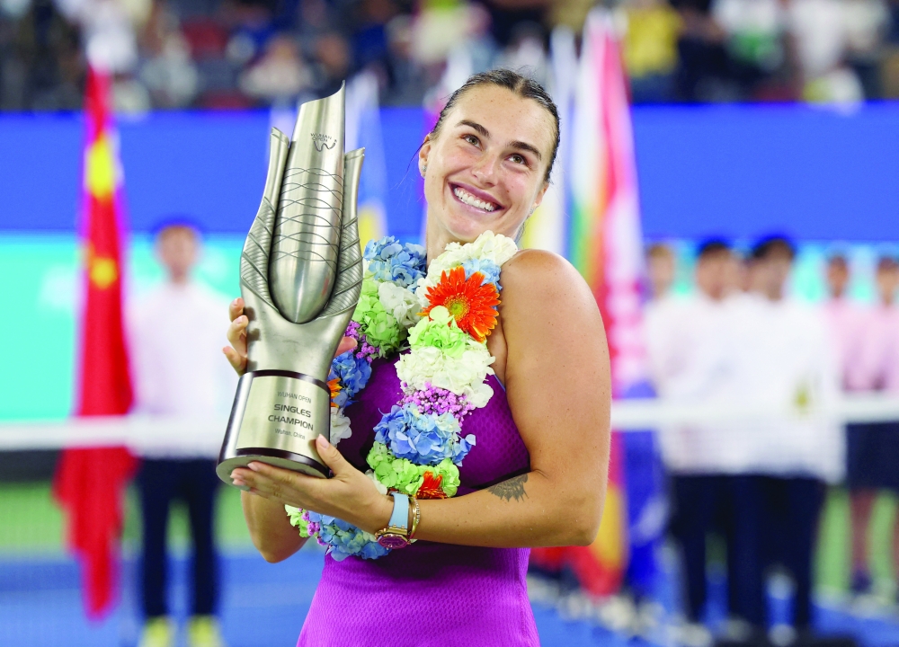 Tennis - Wuhan Open - Optics Valley International Tennis Center, Wuhan, China - October 13, 2024  Belarus' Aryna Sabalenka celebrates with the trophy after winning her final match against China's Qinwen Zheng. — REUTERS