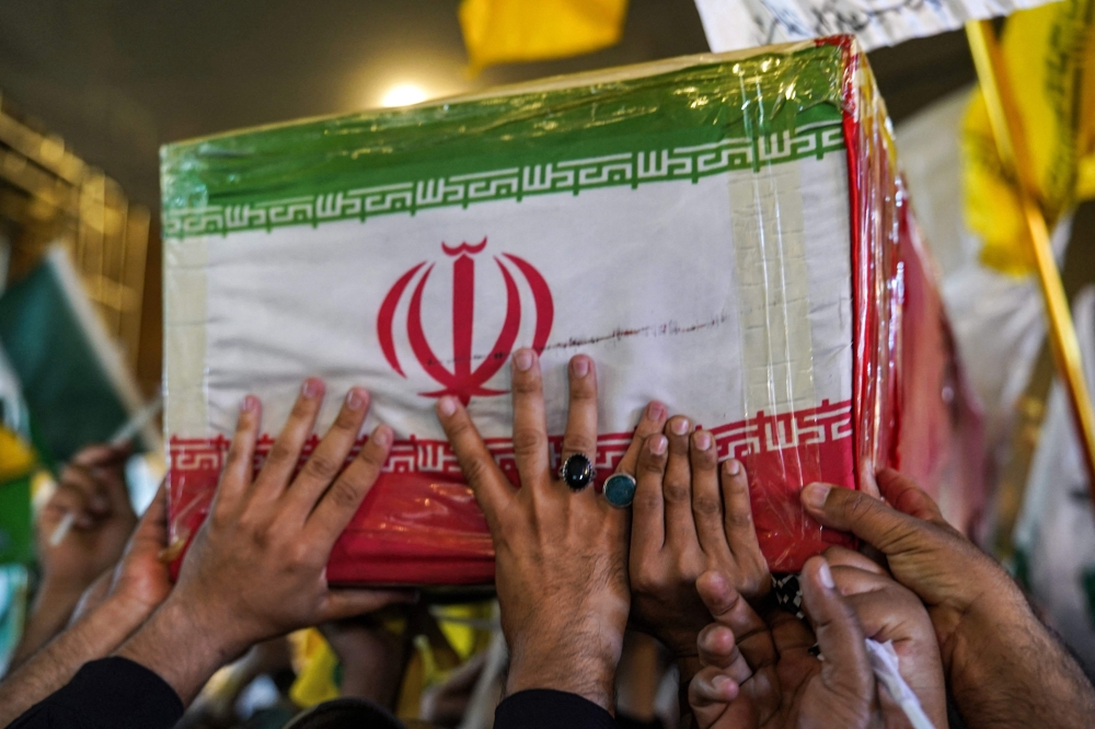 Mourners march with the body of Abbas Nilforoushan, the slain commander in Iran's Islamic Revolutionary Guard Corps (IRGC) who was killed with the leader of the Lebanese Hezbollah movement Hassan Nasrallah in an Israeli air strike on 
