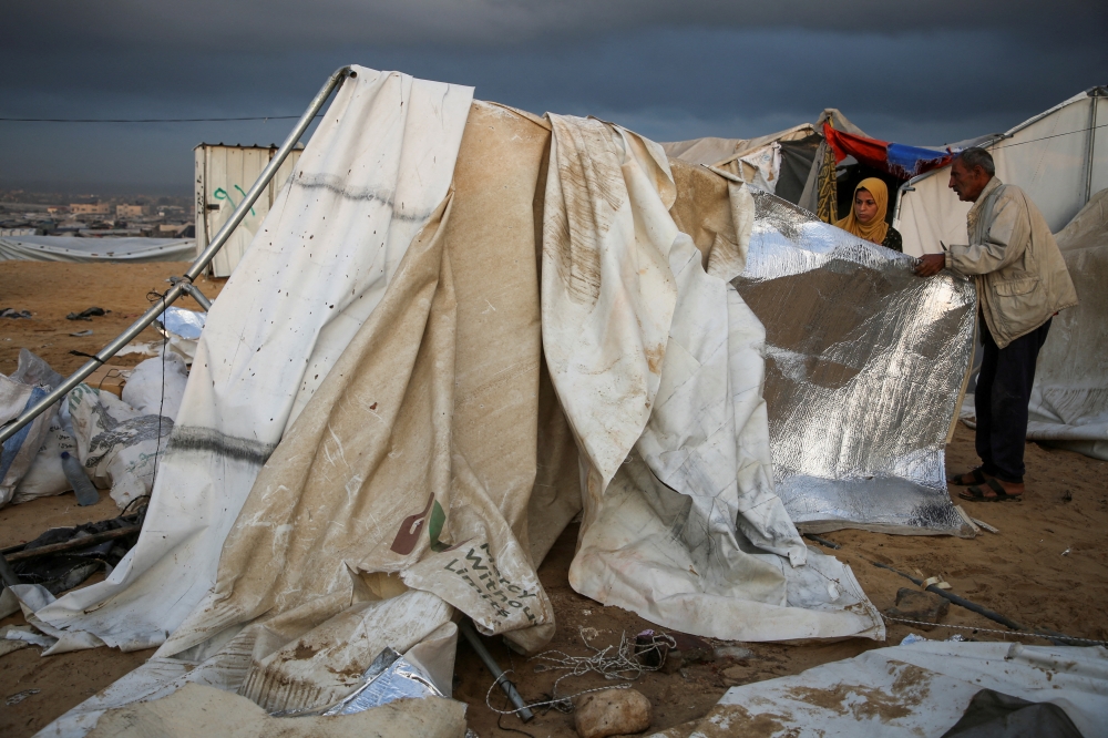Palestinians inspect the damage at the site of an Israeli strike on a tent camp sheltering displaced people in Khan Younis. — Reuters 