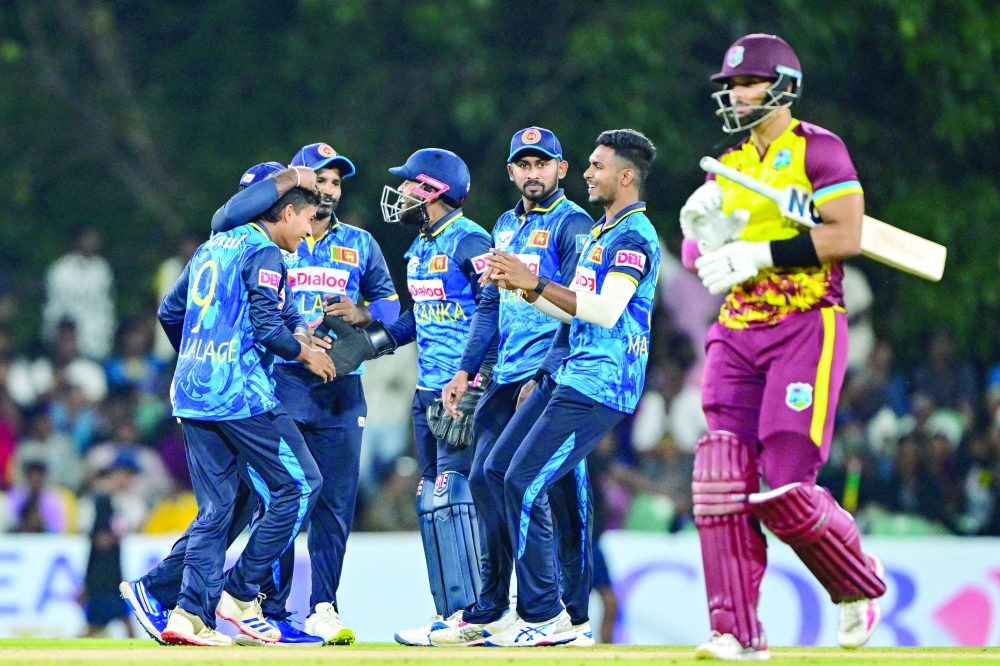 Sri Lanka's Dunith Wellalage (L) celebrates with teammates after taking the wicket of West Indies' Brandon King (R) during the second Twenty20 international cricket match between Sri Lanka and West Indies at the Rangiri Dambulla International Cricket Stadium in Dambulla on October 15, 2024. 