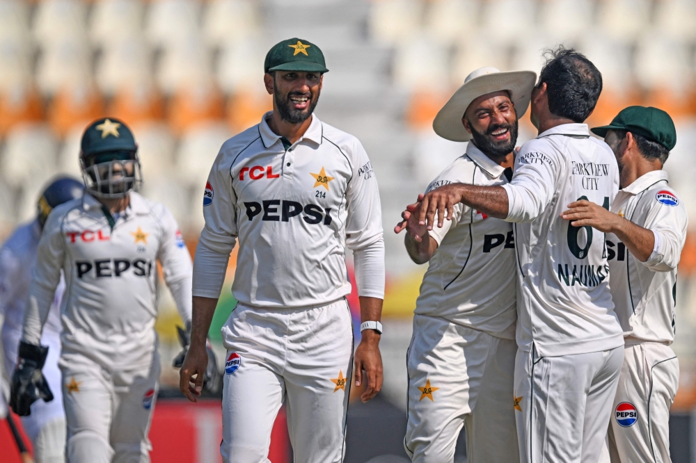 Pakistan's Noman Ali (2R) and Sajid Khan (C) celebrate after the dismissal of England's Jamie Smith during the third day of the second Test cricket match between Pakistan and England at the Multan Cricket Stadium in Multan on October 17, 2024. (Photo by Farooq NAEEM / AFP)


