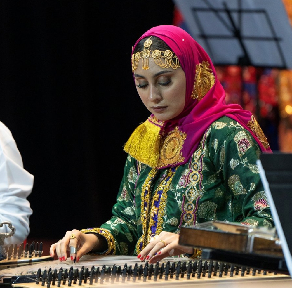 A women student plays a musical instrument during Sultan Qaboos University's celebration Omani Women's Day on Thursday. 