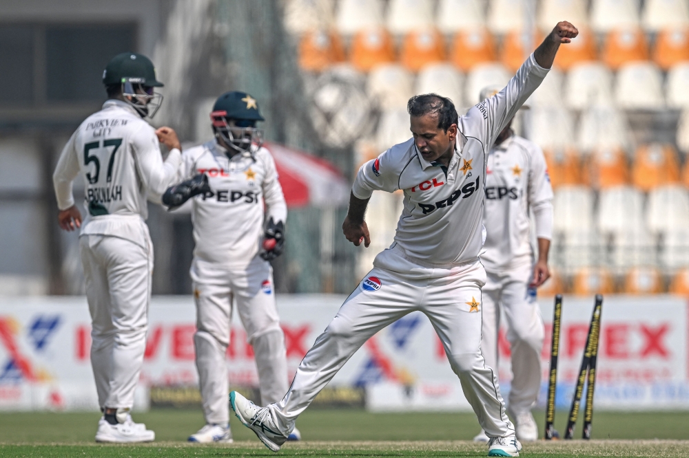 Pakistan's Noman Ali (R) celebrates after the dismissal of England's captain Ben Stokes during the fourth day of the second Test cricket match 