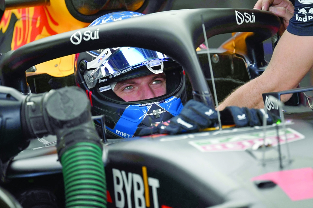 Max Verstappen celebrates in pit lane after taking pole position. — AFP