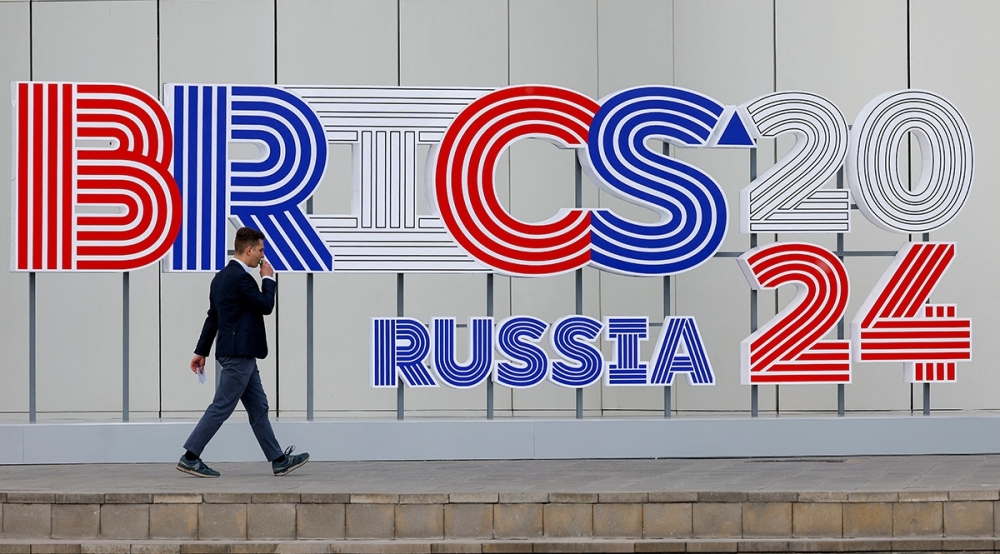 A man walks past the logo of BRICS Summit to be held in Kazan, Russia. — Reuters