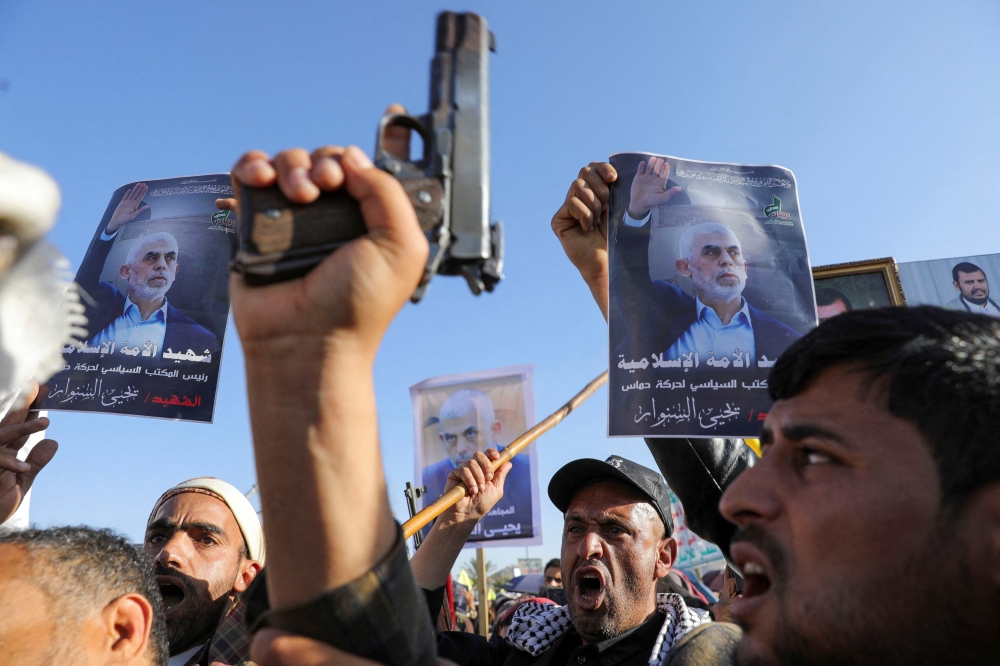 Protesters hold posters showing the late Hamas leader Yahya Sinwar as they rally to show support to Lebanon's Hezbollah and Palestinians in the Gaza Strip in Sanaa. - Reuters