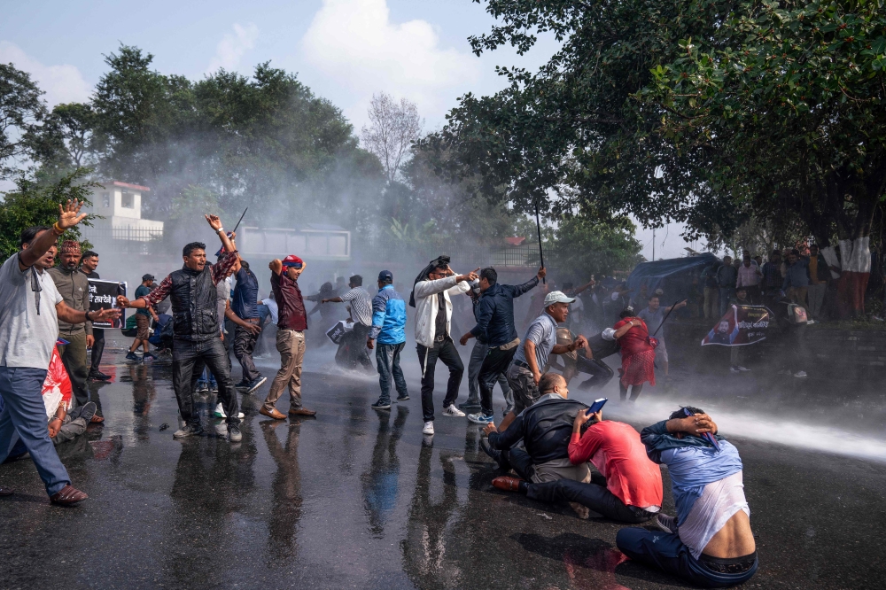 Police use water cannons to disperse supporters of Rabi Lamichhane, in Pokhara. — AFP 