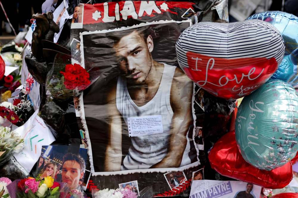 Tributes are placed at a memorial for former One Direction singer Liam Payne, who was found dead after he fell from a third-floor hotel room balcony in Buenos Aires, in Hyde Park, London, Britain, October 20, 2024. REUTERS/Hollie Adams
