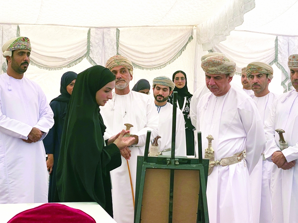 Artist Najla al Hattali explaining her artwork.