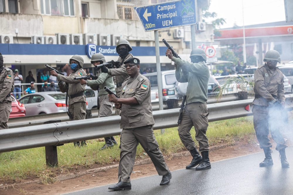 A unit of the Mozambican anti-riot police advances while firing firing tear gas at protesters, in Maputo. — AFP 