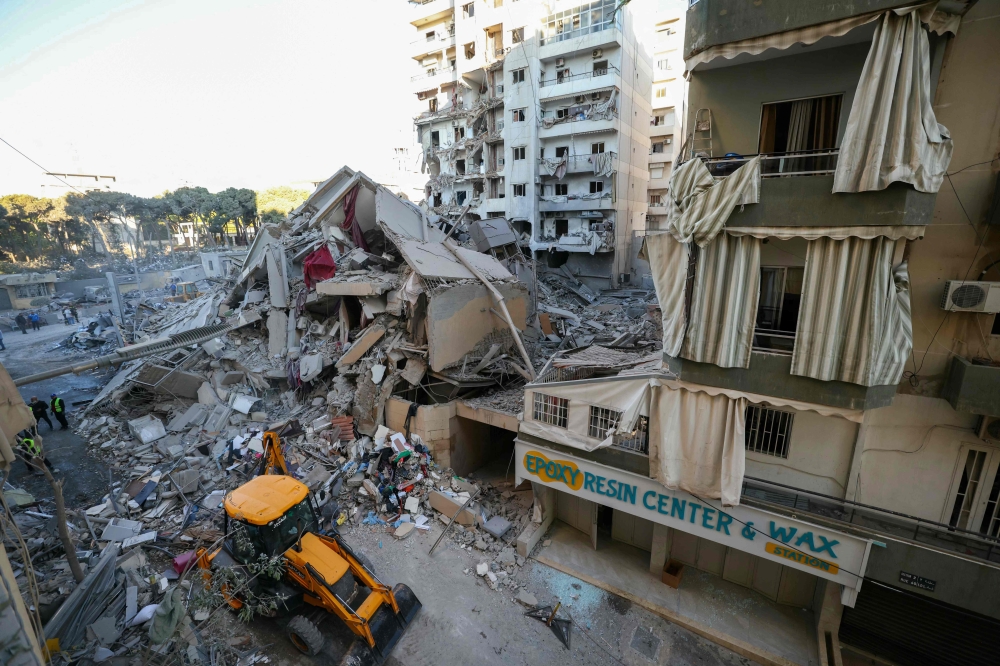 An excavator clears the rubble at the site of an overnight Israeli airstrike, in Beirut southern suburbs. — AFP 