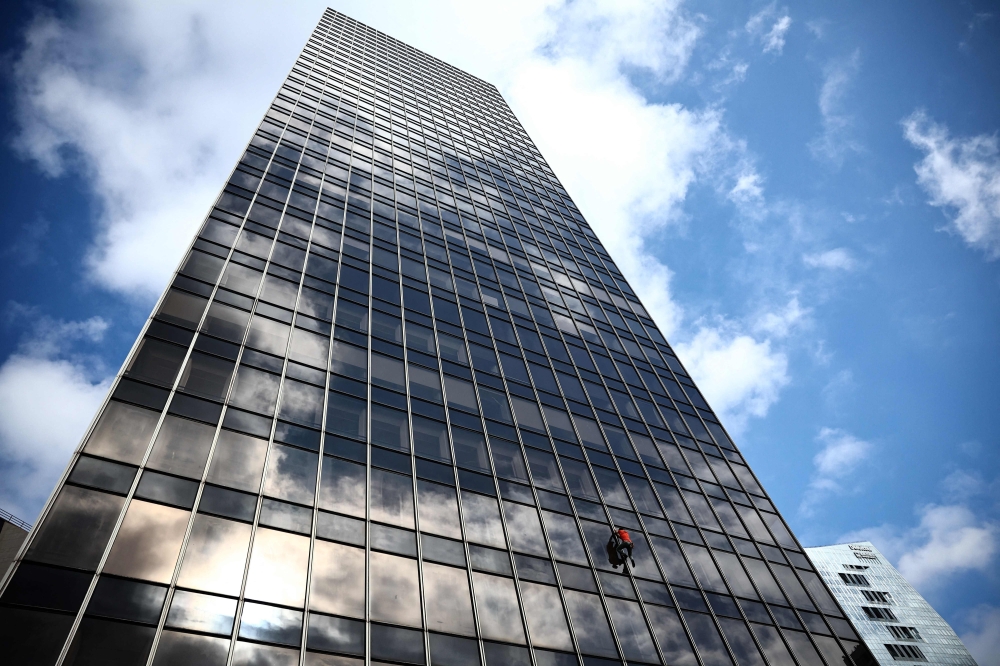 French urban climber Titouan Leduc climbs the Franklin Tower, a 115-metre-high office skyscraper located in La Defense business district, west of Paris, on October 3, 2024. Leduc, a 23-year-old urban climber from northeastern France, likes to scale skyscrapers without any ropes or specialist equipment, wearing only a pair of climbing boots. (Photo by Anne-Christine POUJOULAT / AFP)

