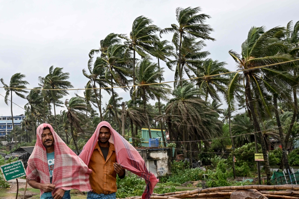Villagers react as they walk on the beach following the landfall of cyclone Dana in East Midnapore district around 180km southwest of Kolkata 