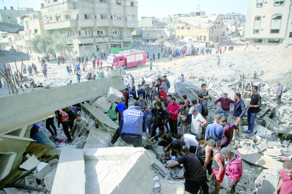 People work to recover Palestinian casualties from the rubble of a house following an Israeli strike in Gaza City. — Reuters