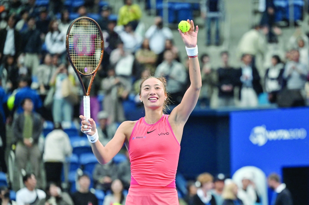 Zheng hits balls into the crowd after the winning. — AFP