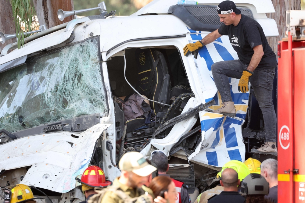 Israeli police and emergency responders secure the truck after a driver rammed his vehicle into a crowd of people at a bus stop in Ramat Hasharon