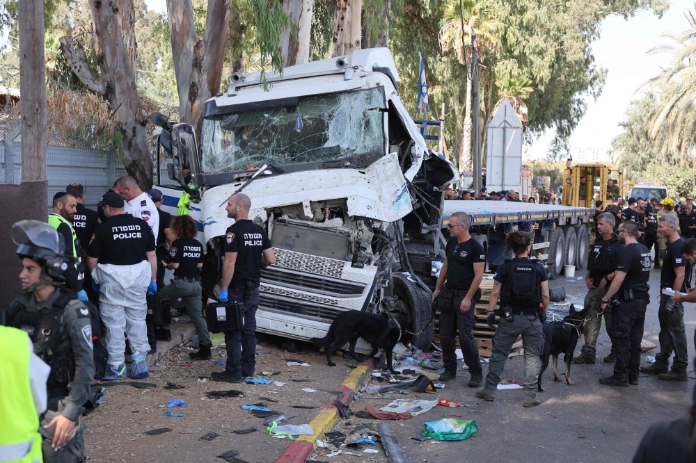 Israeli police and emergency responders secure the truck after a driver rammed his vehicle into a crowd of people at a bus stop in Ramat Hasharon