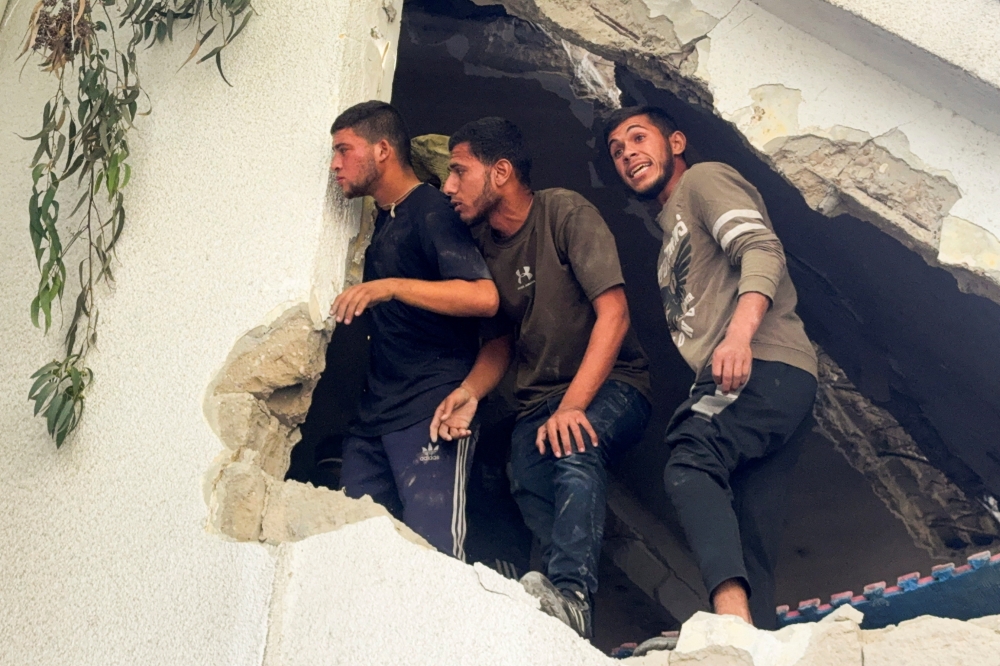 Palestinians inspect the site of an Israeli strike on a school sheltering displaced people, in Gaza City. — Reuters 