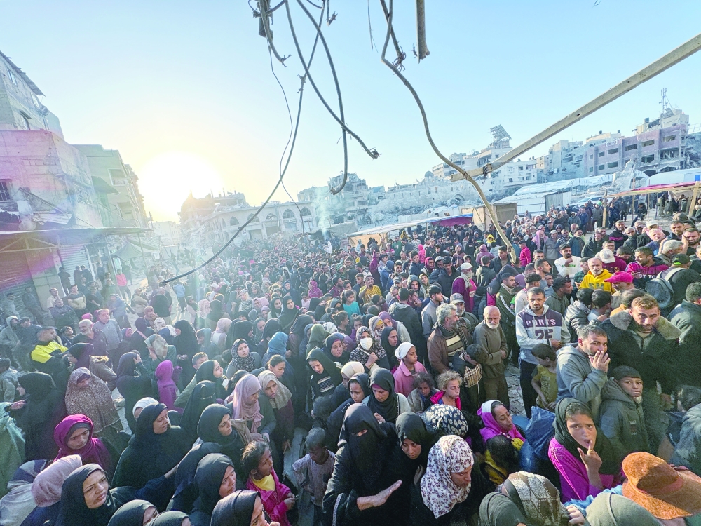 Palestinians gather to buy bread from a bakery, in Khan Yunis. — Reuters