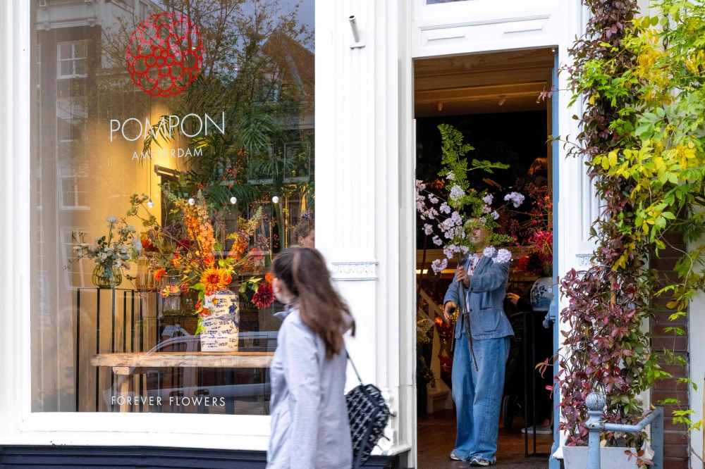 A pedestrian walks past the Pompon flower shop, in Amsterdam on October 23, 2024, as the city launches its 750th anniversary celebrations. This year, De Jordaan is the subject of a musical created to celebrate the 750th anniversary of Amsterdam, for which the festivities kick off on October 27, 2024, and run for a year.
A neighbourhood known for its popular music and outspoken residents, De Jordaan crystallises the changes that have taken place in the Dutch capital, from its working-class origins to its recent gentrification. (Photo by Nick Gammon / AFP)

