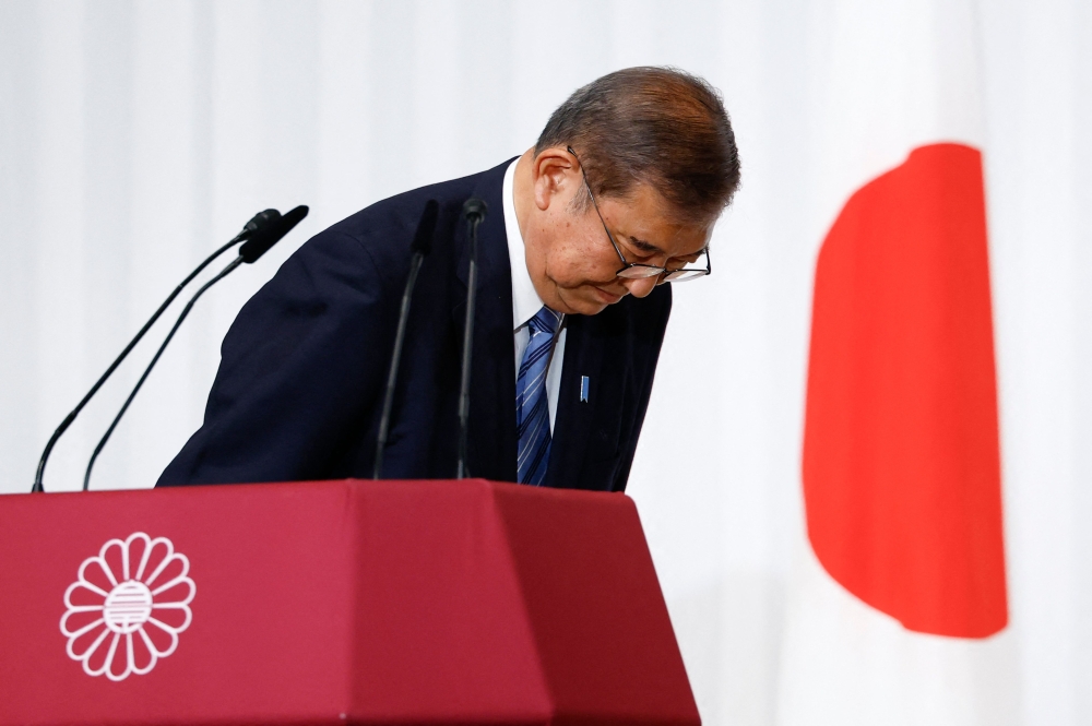 Japan's prime minister Shigeru Ishiba bows to LDP lawmakers onstage, at the party's headquarters in Tokyo. — AFP 