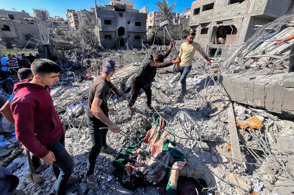 People search the rubble for missing people at the site of an Israeli strike in Beit Lahia, in the northern Gaza Strip. — AFP