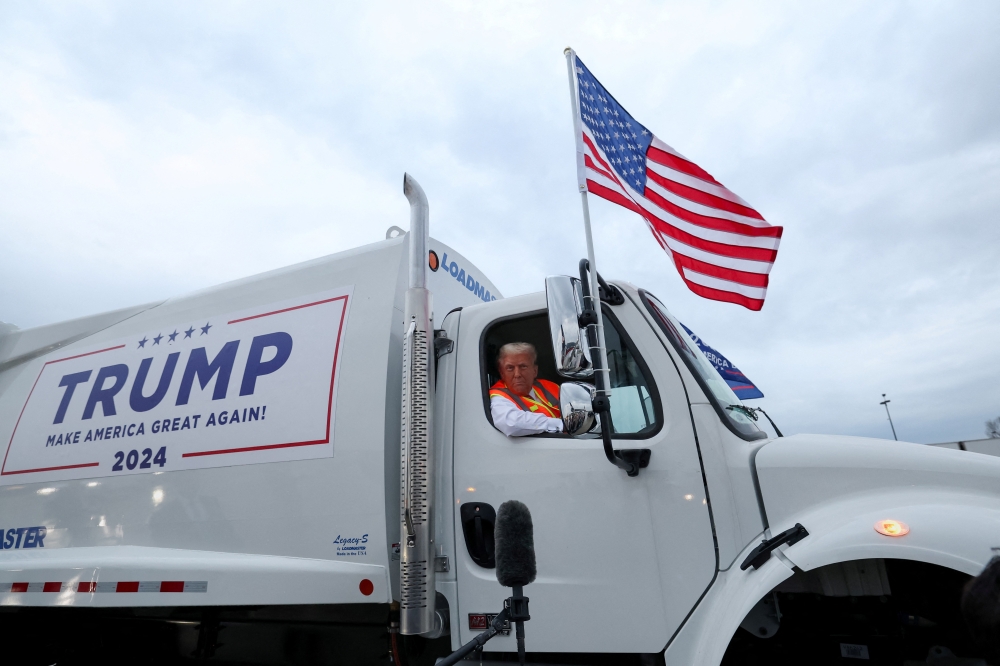 Donald Trump sits inside garbage truck as he wears a high-vis vest, on tarmac at Green Bay Austin Straubel International Airport in Green Bay on Thursday. — Reuters