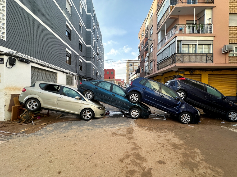 Cars are piled up on a residential street in the aftermath of torrential rains that caused flooding, in Alfafar, Valencia region, on Thursday. — Reuters