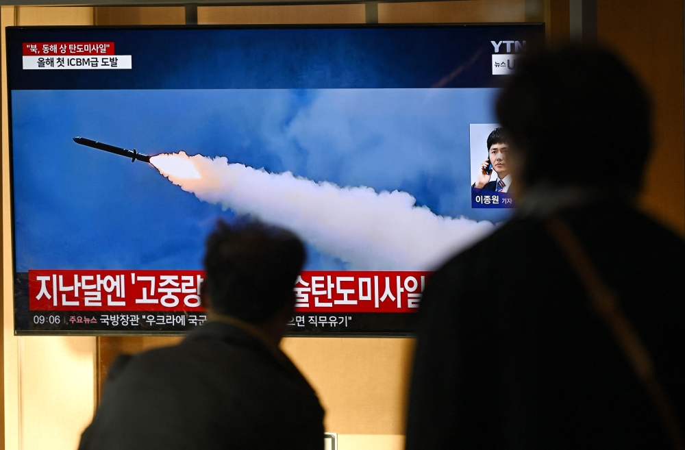 People watch a television screen showing a news broadcast with file footage of a North Korean missile test, at a train station in Seoul Thursday. — AFP